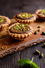 Tartlets with chocolate, pistachios and lime peel