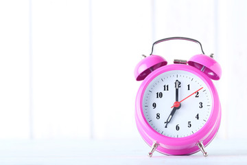 Pink alarm clock on a white background