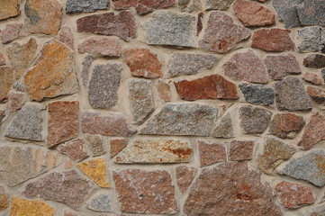 Background wall made of stones held together with cement. Wall made of stones close-up