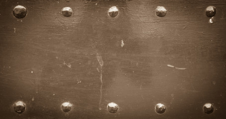 Sepia old metal background with rivets. Vintage abstract texture with shading borders.