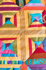 Naklejka premium Part of symmetric geometry pattern color patchwork quilt as background. Colorful Scrappy blanket. Handmade.