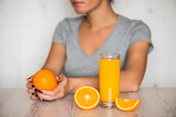 healthy drink, diet, detox and people concept - close up of woman with orange juice in glass