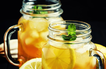 Ice black tea with lemon and mint, low key, selective focus