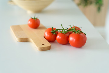 Red tomatoes with a board in the kitchen