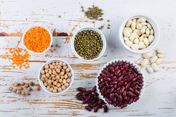 Selection of colorful beans on white wood background