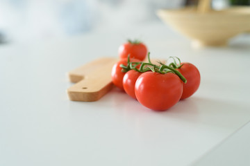 Red tomatoes with a board in the kitchen
