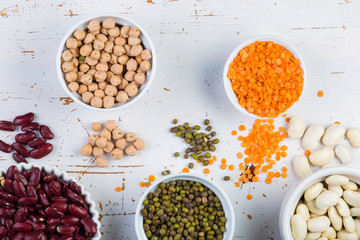 Selection of colorful beans on white wood background