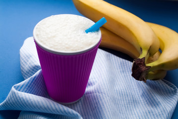 milkshake in a ceramic cup with a straw, bananas