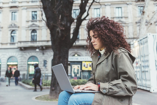 Young beautiful mixed race woman outdoor in the city using computer - working, business, technology concept