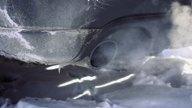 Car pipe puffs exhaust gas clouds. Smoke clouds coming out of automobile tailpipe. Air and environment pollution by vehicle closeup slow motion shot.
