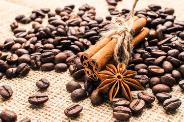 Coffee beans with cinnamon and anise on the sackcloth