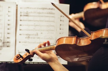 Violinist playing in orchestra close up