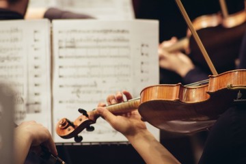 Violinist playing in orchestra close up
