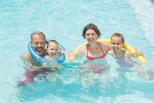 Happy parents and kids having fun in pool