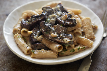 Pasta rigatoni with mushroom sauce and nuts