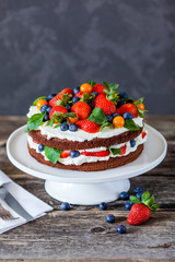 Delicious homemade biscuit cake with berries on wooden table