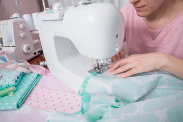 beautiful woman seamstress sew on the sewing machine clothes.