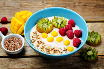 Breakfast oatmeal porridge with kiwi, mango, raspberry, banana and flax seeds