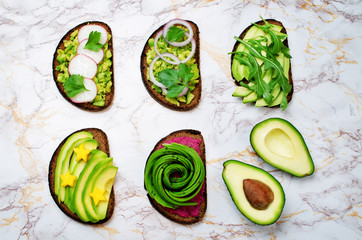 Variation of healthy rye breakfast sandwiches with avocado, hummus, and berries. toning. selective focus