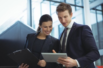 Business executives discussing over digital tablet on stairs