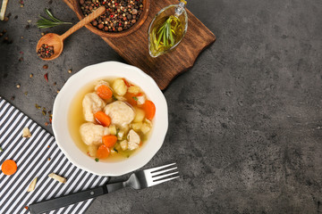 Bowl with delicious chicken and dumplings on kitchen table