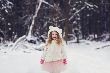 Fototapeta na wymiar winter portrait of adorable smiling kid girl in hat