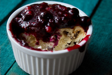 half eaten portion of cheesecake with raisins in white ramekin