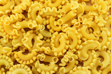 Dry colored italian pasta on a wooden table