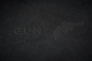 Umriss einer Waffe in schwarzem Stein mit dem Wort GUN daneben