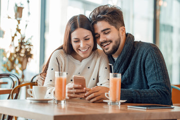 Happy young couple having fun in cafe