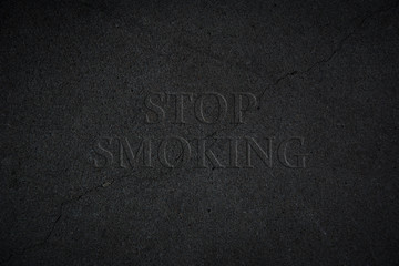 Fototapeta na wymiar Stop Smoking auf schwarzem Hintergrund aus Stein mit einem Riss