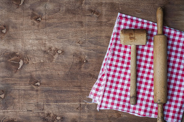 Wooden kitchen items on a red napkin, rolling pin and hammer for beating meat