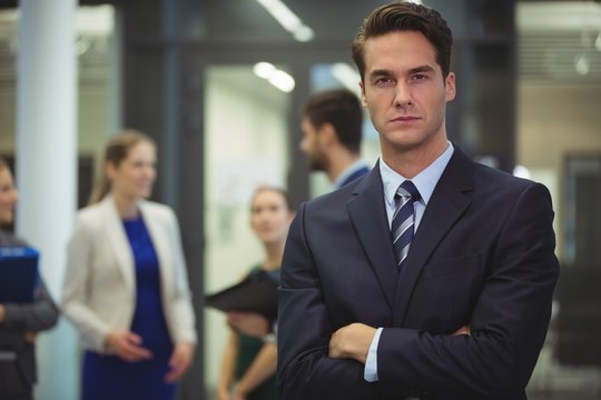 Businessman standing with arms crossed in the office