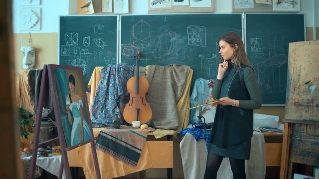 Woman artist looking at her final painting