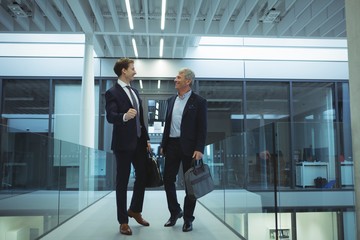 Two businessman interacting with each other in corridor 