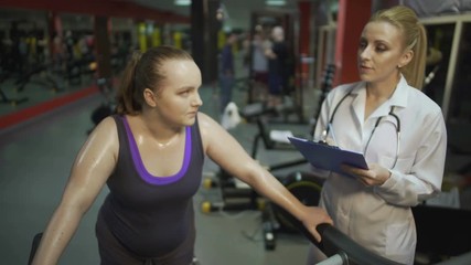 Female nutritionist consulting overweight woman on healthy diet for weight loss