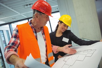 Businesswoman discussing over blueprint with a architect