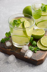 Cold refreshing summer drink in a glass on a grey concrete or stone background, selective focus, copy space