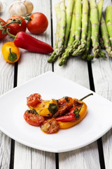 Roasted bell peppers with tomato sauce on the white rectangular plate. Rustic style.  