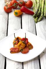 Roasted bell peppers with tomato sauce on the white rectangular plate. Rustic style.  