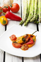 Roasted bell peppers with tomato sauce on the white rectangular plate. Rustic style.  