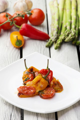 Roasted bell peppers with tomato sauce on the white rectangular plate. Rustic style.  