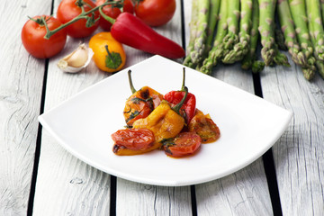 Roasted bell peppers with tomato sauce on the white rectangular plate. Rustic style.  
