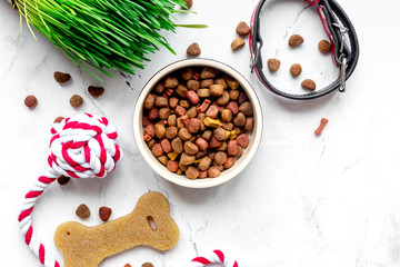 dry dog food in bowl on stone background top view