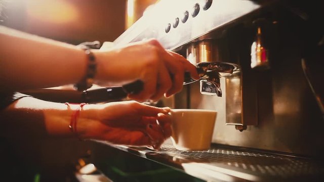 Dolly shot of a barista preparing an espresso coffee in a bar. 