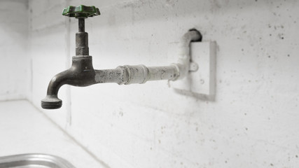 Old wall faucet, tap in garage or utility room, warehouse, workshop