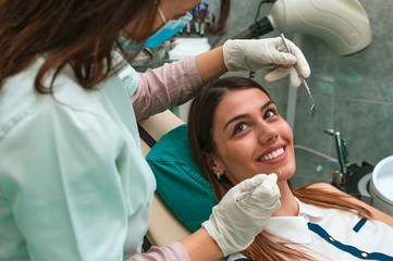 Smiling setisfied female patient at the dentist's office