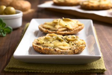 Baked ham, green olive and cheese sandwich with oregano, photographed with natural light (Selective...