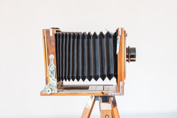 Old vintage big camera made of wood and metal on white background close-up side view