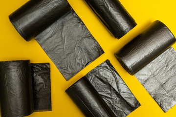 New black garbage bags on a yellow background.